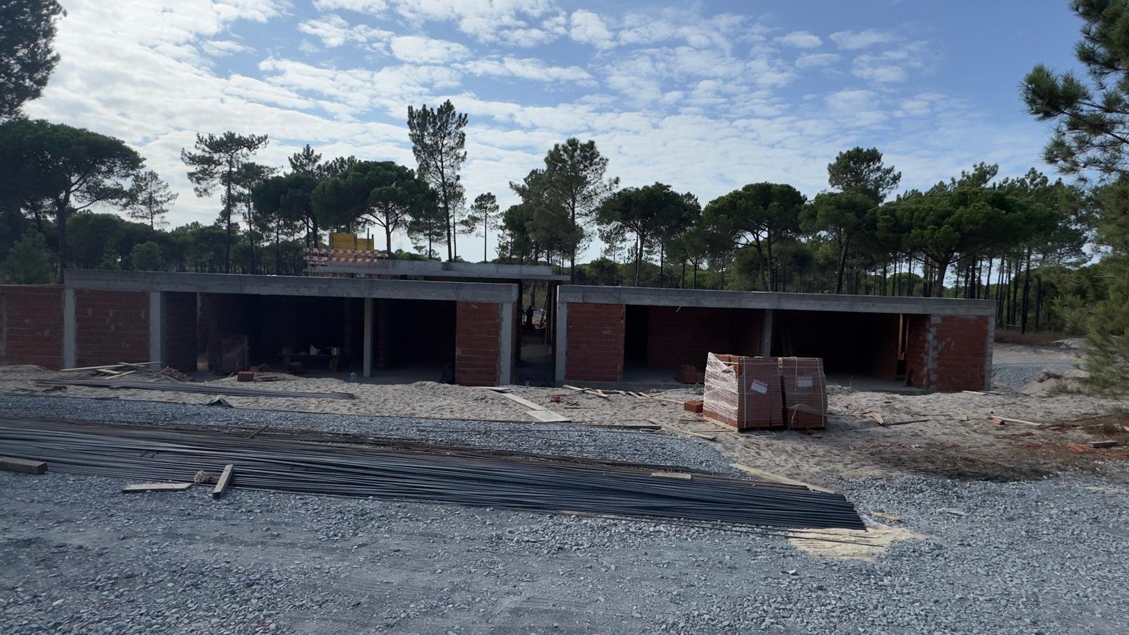 Moradia em construção: estrutura em betão e alvenaria de tijolo, no meio do pinhal
